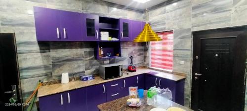 乌约THE MARBLE ARCH的厨房配有紫色橱柜和黄色灯