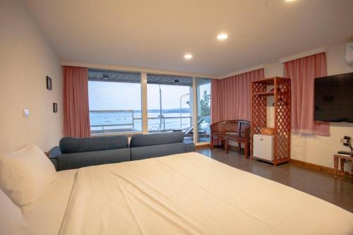南湾蝴蝶旅店的一间卧室配有一张床、一张沙发和一台电视