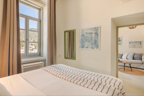 伊兹拉海德拉酒店的白色的卧室设有床和窗户