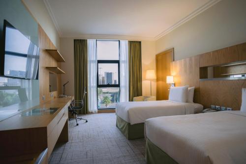 阿布扎比阿布扎比假日酒店的酒店客房设有两张床和窗户。