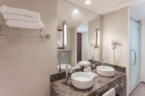 阿布扎比阿布扎比假日酒店的浴室设有2个水槽和镜子