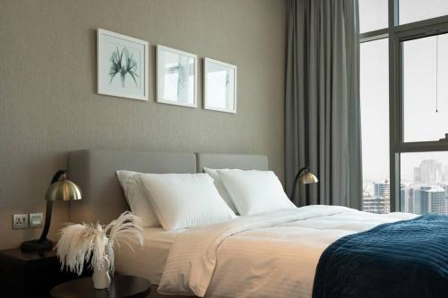 迪拜Business Bay centrally located Cozy Studio的一间卧室配有一张带白色床单的床和一扇窗户。