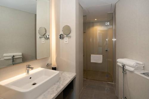 迪拜Business Bay centrally located Cozy Studio的白色的浴室设有水槽和淋浴。