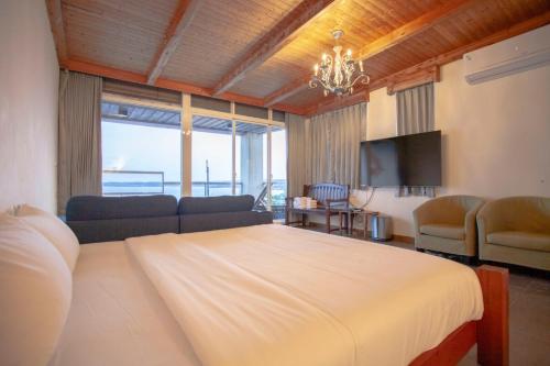 南湾蝴蝶旅店的一间卧室配有一张床、一张沙发和一台电视。