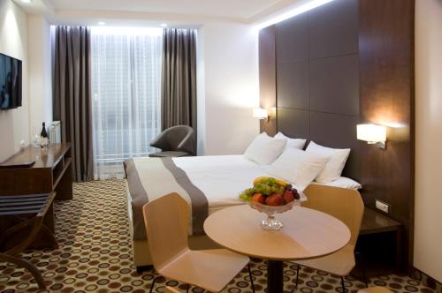 索非亚索非亚中心大酒店的酒店客房,配有一张床和一碗水果放在桌子上
