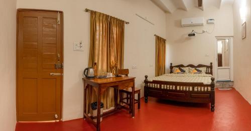 蓬蒂切里Parambara Heritage的一间卧室配有一张床和一扇木门