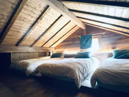 夏蒙尼-勃朗峰Le Chalet Georges的木墙客房的两张床
