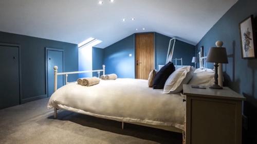 利德尼Oak Tree Cottage的一间卧室配有一张带蓝色墙壁的大床