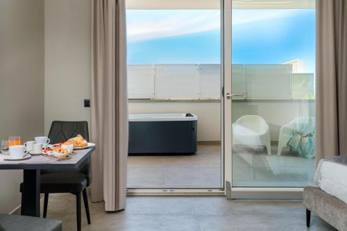 切法卢Emerald Hotel Residence Cefalù的一间带桌子的客厅,享有浴缸的景色