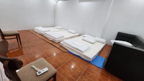 Dien Bien PhuA Thía Hostel的一间房间,地板上设有三张床垫