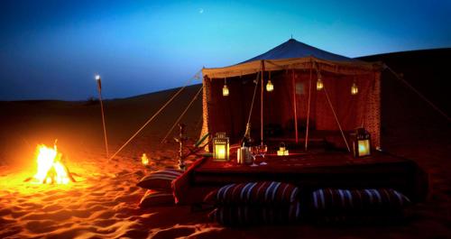 斋沙默尔Jaisalmer Night Safari Camp的沙漠中的帐篷,沙中着火