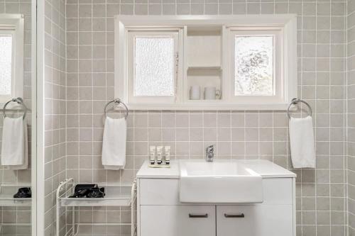 肯图巴Charming Blue Mountains Cottage - Katoomba的白色的浴室设有水槽和镜子