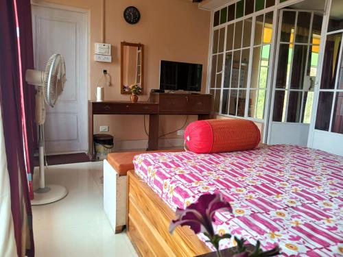 噶伦堡SAI´S GRACE的一间卧室配有一张床和一张带风扇的书桌
