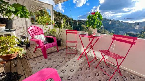 派西亚Paihia Loft Walk to Beach, Eats and Culture的一组粉红色的椅子和一张桌子