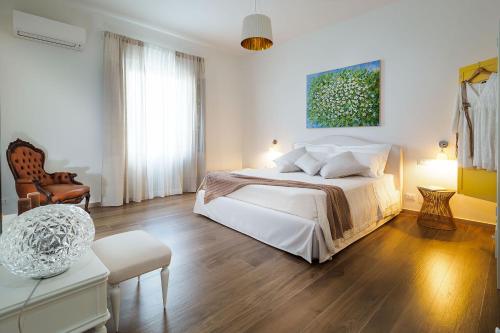 马劳萨Pietra del Sole的白色卧室配有床和椅子