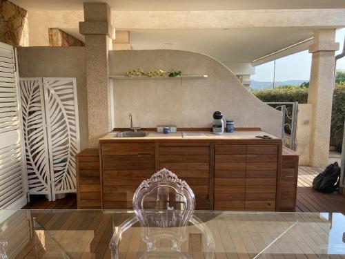 帕劳LOTUS Wellness Apartment - Resort Ginestre - Palau - Sardinia的天井上设有带水槽和椅子的厨房