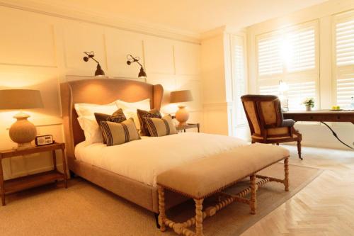 罗斯奈格尔Sandy Mount House的一间卧室配有一张带椅子的床和一张书桌
