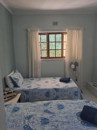 爱德华港Eden Wilds 6 Paradise on Umtavuna River的一间卧室设有两张床和窗户。