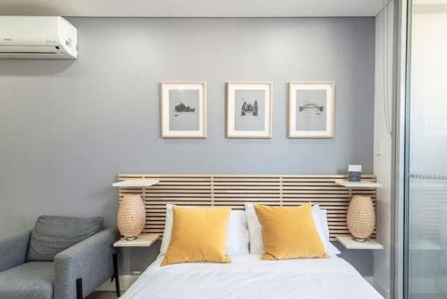 悉尼Studio in Crown St - Private Balcony & Aircon的一间卧室配有一张带黄色枕头和椅子的床