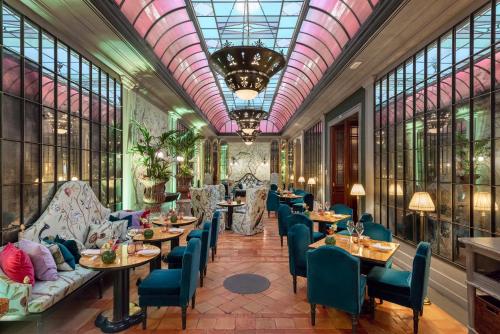 佛罗伦萨佛罗伦萨海尔维迪亚&布里斯托尔酒店 - 星际酒店集团的餐厅设有桌椅和窗户。