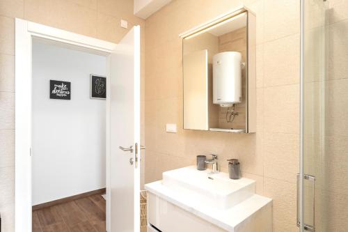 伊万多拉克Seafront Apartment Totally Beachin with Private Pool的一间带水槽和镜子的浴室