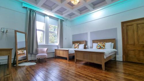 阿什顿下安林恩Sleeps 20 Stunning Ashton Mansion的一间卧室设有两张床和窗户。