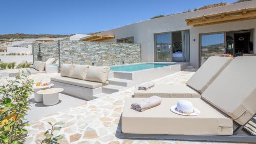阿达玛斯Solus Suites Milos的一个带白色家具的庭院和一个游泳池