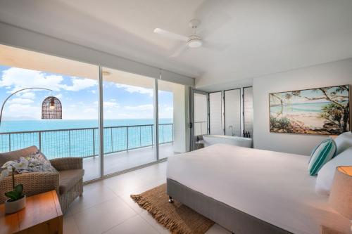 耐莉湾美爵公寓磁岛酒店的一间带大床的卧室,享有海景