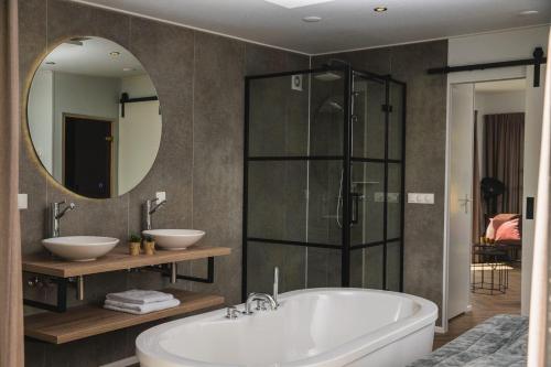 莱森Panorama lodge with wellness and hottub 2 p.的一间带浴缸和大镜子的浴室