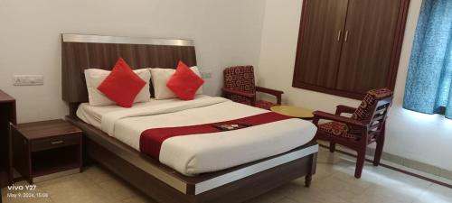 钦奈Mount Heera Hotel-Alandur的一间卧室配有一张带红色枕头的大床