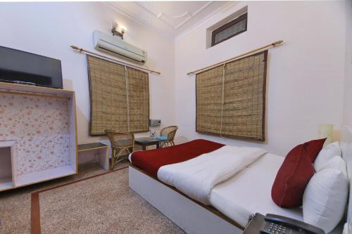 NarendranagarOYO Radhe Krishana Guest House的一间卧室设有一张带壁炉和电视的床。