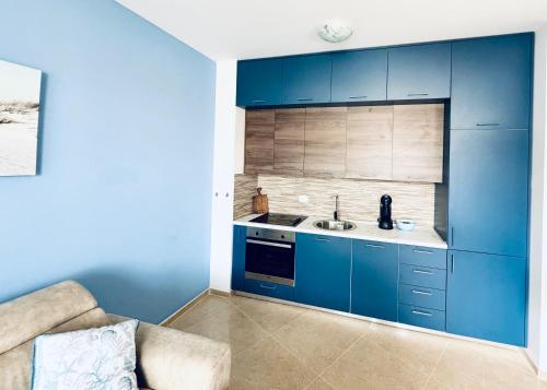拉法洛维奇Sea Glass Sunset的厨房配有蓝色橱柜和水槽