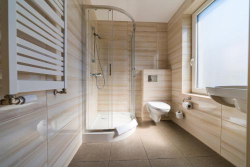 德布吉Magnolia pokoje i apartamenty Dębki的带淋浴、卫生间和盥洗盆的浴室