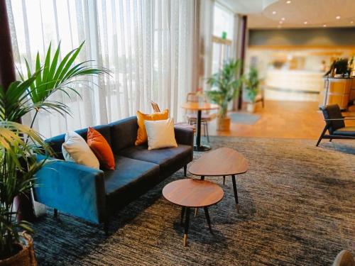 卡迪夫加的夫湾未来旅馆的客厅配有蓝色的沙发和2张桌子