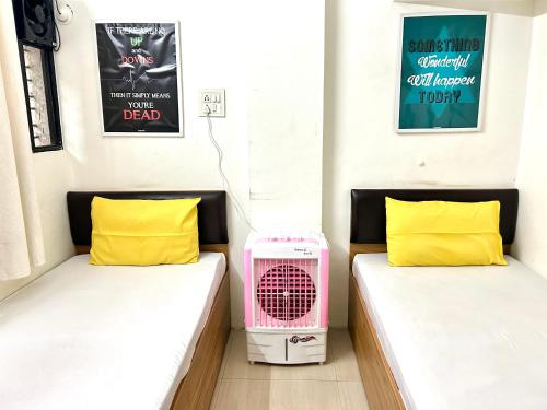 浦那Procida Hostel by Zero Jhanjhat的小型客房配有2张床和风扇。