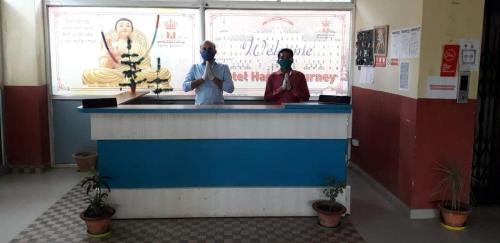DīghaOYO Hotel Happy Journey的两个人戴面具站在柜台