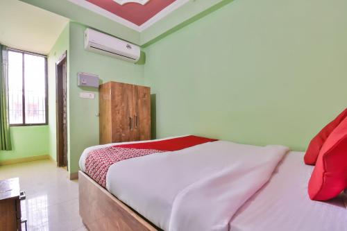 DīghaOYO Hotel Happy Journey的一间设有床铺的卧室,位于一个拥有绿色墙壁的房间