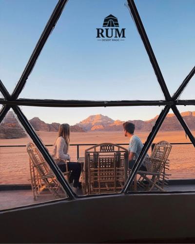 瓦迪拉姆Rum desert magic的两个人坐在桌子上,看着水面