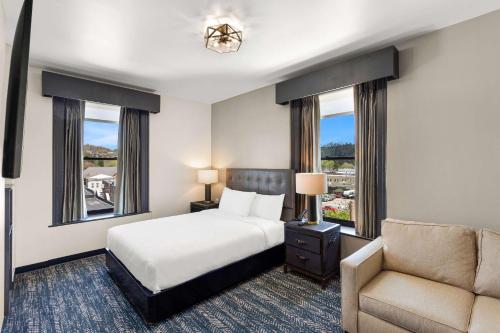 埃尔金斯Tygart Hotel, Ascend Hotel Collection的一间卧室配有一张床、一把椅子和窗户。