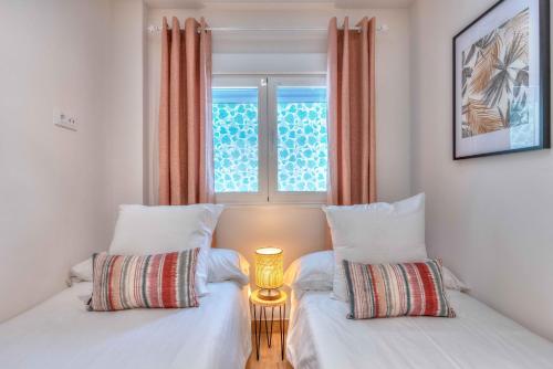 马德里Apartamento Metropolitano II en Madrid的带窗户的客房内的两张床