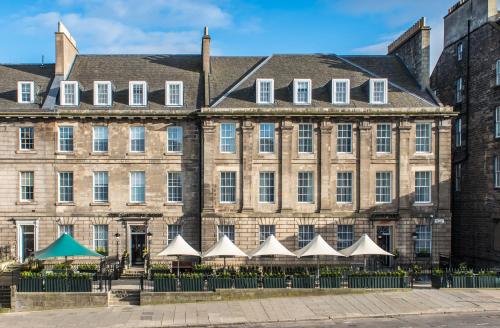 爱丁堡爱丁堡万豪万怡酒店的一座古老的建筑,前面有白色的伞