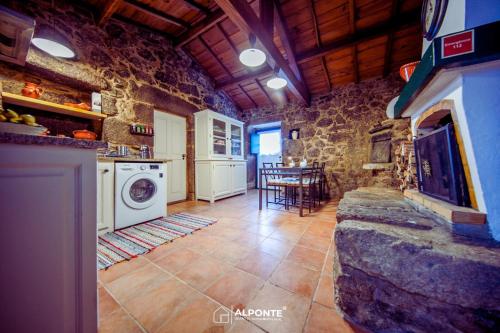 São MamedeRefugio dos Cartolas By ALPONTE的石头建筑中带洗衣机和烘干机的厨房