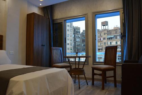 开罗tourist hotels cairo downtown的酒店客房,配有一张床和一张桌子及椅子