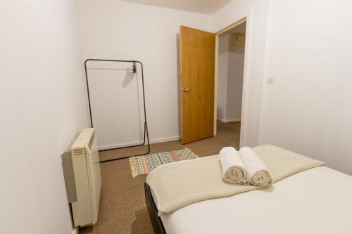 谢菲尔德Comfy Chic 2Bed Apartment in Sheffield City Centre的一间卧室配有一张床,上面有两条毛巾