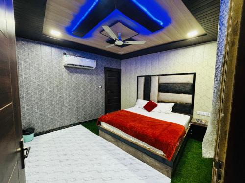 阿格拉hotel chahat palace的一间卧室配有一张蓝色天花板的床