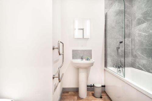 利物浦Modern 1 Bed Apartment in Bootle Liverpool的白色的浴室设有水槽和淋浴。