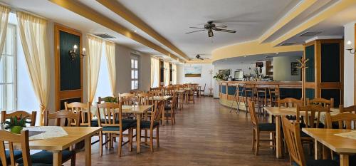 雷德尼斯扎莫奇莱德尼斯酒店的一间带木桌椅的餐厅和一间酒吧