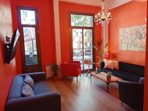 巴塞罗那Paraiso Hostel的客厅设有红色的墙壁和蓝色的沙发