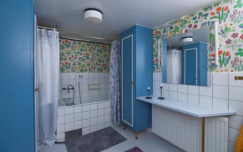 赖特维克Mysigt boende I Rättvik med utsikt över Siljan的浴室设有蓝色橱柜、水槽和淋浴。
