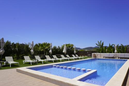 普拉亚登博萨Los Escondidos Ibiza的一个带躺椅的游泳池和一个游泳池